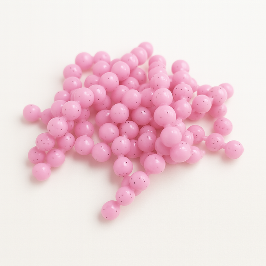 Pink trout eggs on a white background