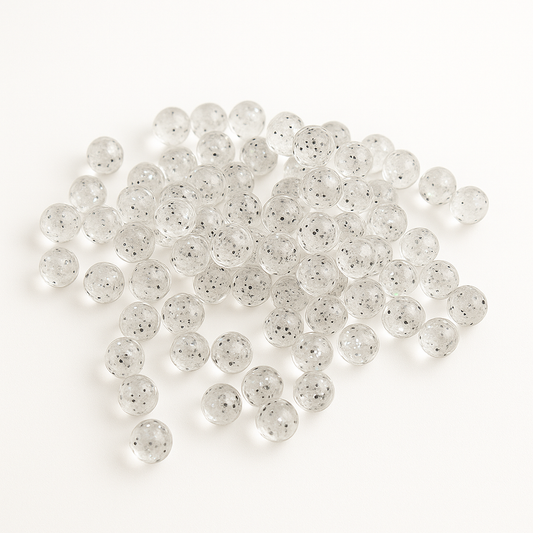 Clear salmon eggs with small black specks on a white background